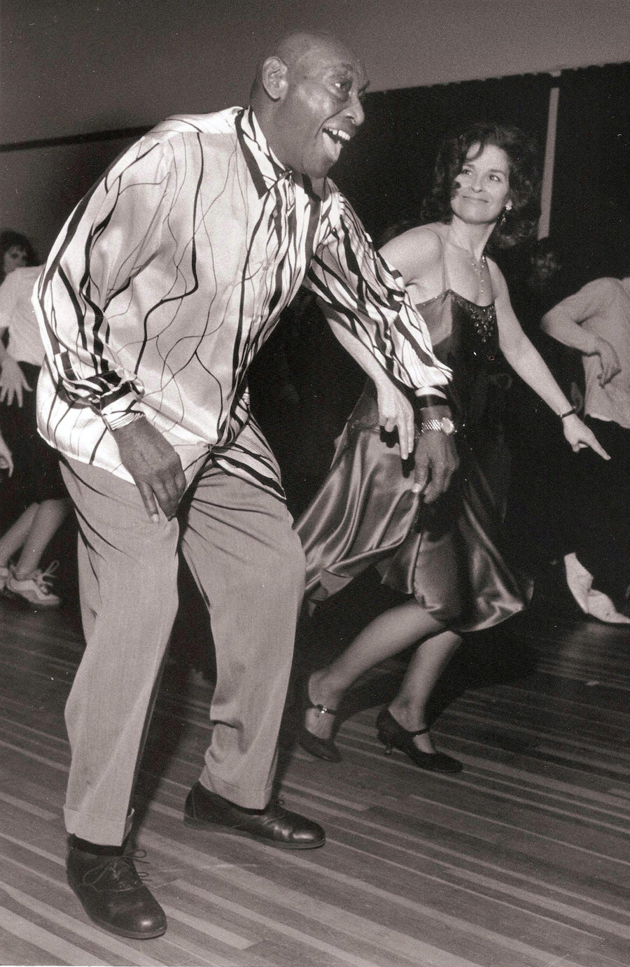 Frankie Manning laughing mid-dance on a crowded dance floor